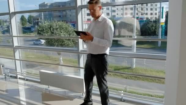 Зрілий бізнесмен біля вікна з планшетом — стокове відео