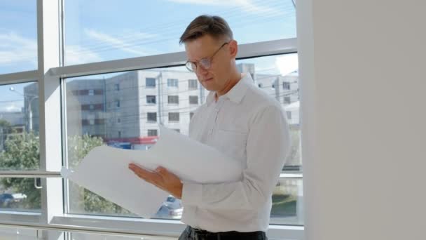 Hombre de negocios maduro en una ventana con un escanea un dibujo en papel — Vídeo de stock