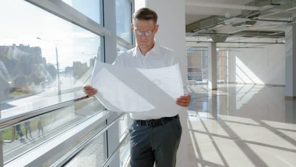 Hombre de negocios maduro en una ventana con un escanea un dibujo en papel — Vídeos de Stock
