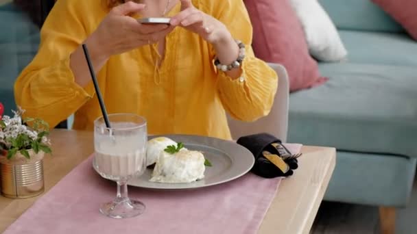 Femme prenant des photos de salade savoureuse avec téléphone portable au restaurant — Video