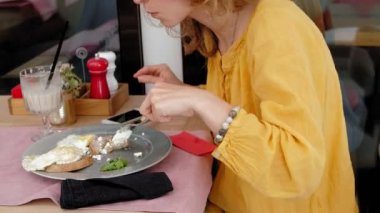 Kahvaltı tost yumurta ile gelen bir kafede güzel genç kadın