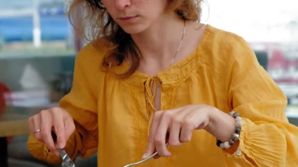 Hermosa mujer joven desayunando de tostadas con huevos en un café — Vídeo de stock