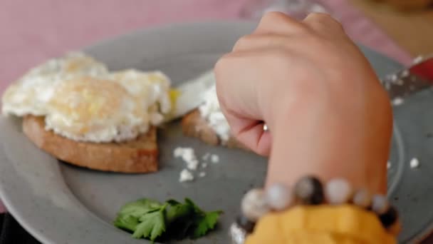 Bella giovane donna che fa colazione dal pane tostato con uova in un caffè — Video Stock