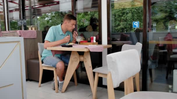 Uomo maturo che fa colazione dal pane tostato con uova in un caffè — Video Stock