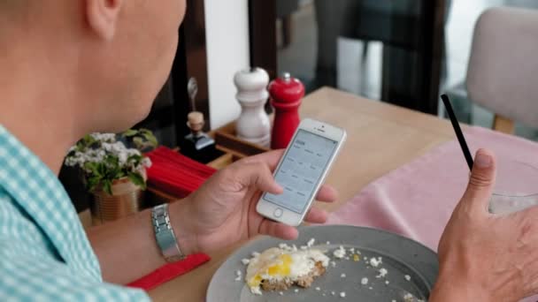 Uomo maturo che fa colazione dal pane tostato con uova in un caffè — Video Stock