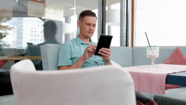 Homme mûr à l'aide de tablette écran tactile dans le café — Video