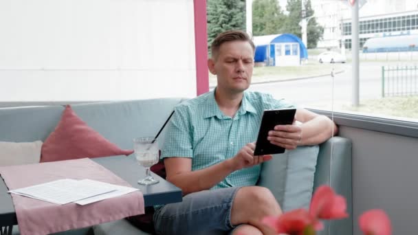 Volwassen man met tablet computer touchscreen in café — Stockvideo