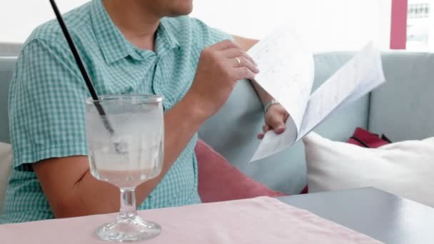 Hombre maduro hojeando documentos en un café — Vídeos de Stock