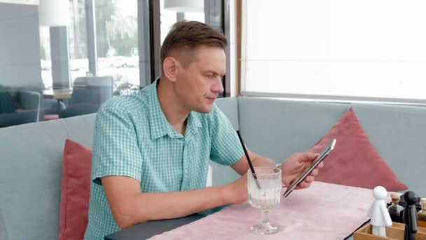 카페에서 태블릿 컴퓨터 터치 스크린을 사용 하 여 성숙한 남자 — 비디오
