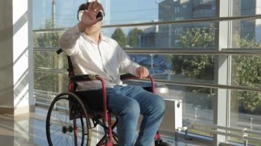 bir pencere, bir tekerlekli sandalye Engelli adam bir kask sanal gerçekliğin kullanır