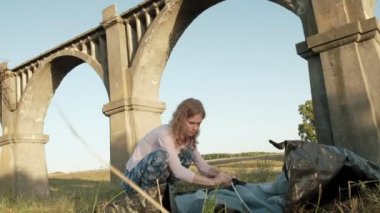 Genç kadın eski Köprüsü yakınlarında bir turist çadır toplar