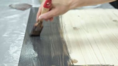 Atölye kadında ahşap kurullarında, antik bir efekt oluşturarak çalışıyor