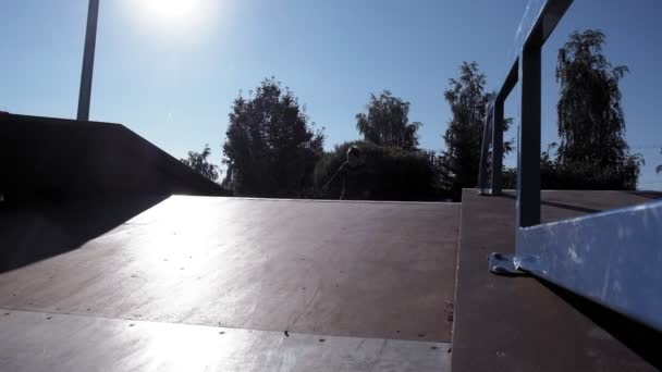 Ein Junge reitet an einem sonnigen Tag in einem Skateboard-Park seine Tricks mit dem Fahrrad. Superzeitlupe — Stockvideo