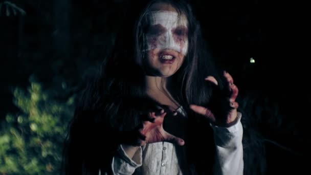 A walk through the night forest - a zombie-undead girl, obsessed with evil attacks on the camera — Stock Video