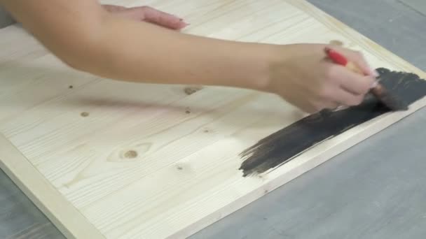 Kvinnan i workshopen arbetar på brädor, vilket skapar en effekt av antiken — Stockvideo