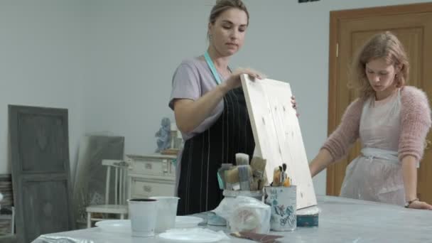 La mujer en el taller está trabajando en tablas de madera, creando un efecto de la antigüedad — Vídeos de Stock