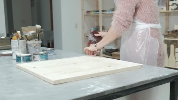 The woman in the workshop is working on wooden boards, creating an effect of antiquity — Stock Video