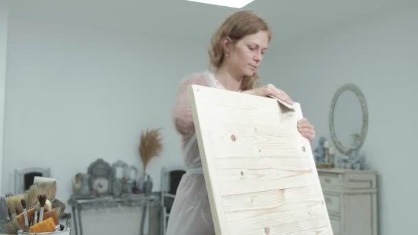 De vrouw in de werkplaats is bezig met houten planken, maken van een effect uit de oudheid — Stockvideo