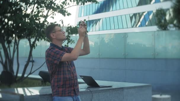 Jonge zakenman is wandelen in het city park business center — Stockvideo