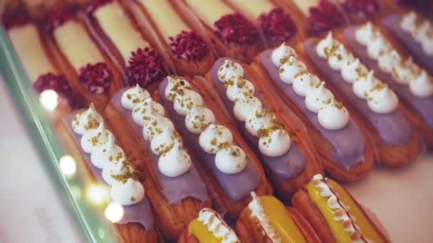 Ze koper kiest lekker. Aantrekkelijk meisje, vrouw koopt in de koffiewinkel of gebak, cake, taart, macaroon. Een koper die permanent onder een glas geval bij de bakkerij, de winkel van de koffie — Stockvideo