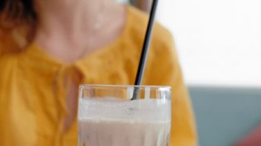 Güzel bir genç kadın bir güler yüzlü yüzlü bir kafede içecekler.