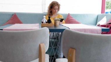 tablet bilgisayar dokunmatik kafede kullanan kadın