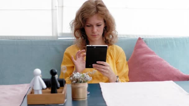Mujer que utiliza la pantalla táctil de la tableta en la cafetería — Vídeo de stock