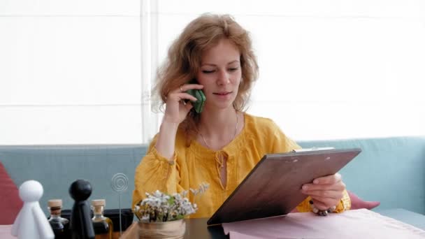 Woman looking at menu in restaurant, turning pages and choosing plates for dinner lunch event dating — Stock Video