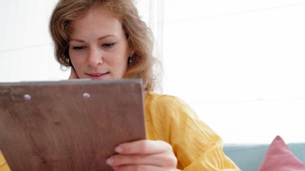 Mujer mirando el menú en el restaurante, pasando páginas y la elección de platos para la cena evento almuerzo citas — Vídeos de Stock