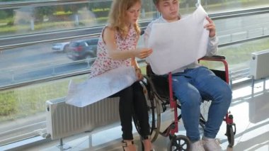 bir büyük iş bir iş kadını, ofisteki tartışma ile tartışırken kağıt üzerine bir resim ile bir tekerlekli sandalyede bir pencere üzerinde işadamı devre dışı...