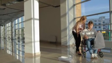 bir büyük iş bir iş kadını, ofisteki tartışma ile tartışırken kağıt üzerine bir resim ile bir tekerlekli sandalyede bir pencere üzerinde işadamı devre dışı...