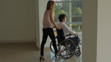 Telefonda konuşan bir tekerlekli sandalye Engelli bir işadamı ile bir tekerlekli sandalye üzerinde wheeling iş kadını
