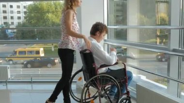 Telefonda konuşan bir tekerlekli sandalye Engelli bir işadamı ile bir tekerlekli sandalye üzerinde wheeling iş kadını