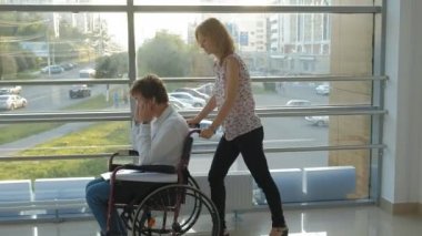 Telefonda konuşan bir tekerlekli sandalye Engelli bir işadamı ile bir tekerlekli sandalye üzerinde wheeling iş kadını