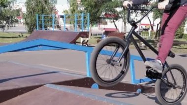Bir çocuk Bmx Bisiklet hileler kaykay parkı güneşli bir günde biniyor. Çok yavaş hareket