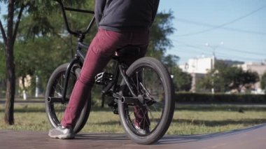 Bir çocuk Bmx Bisiklet hileler kaykay parkı güneşli bir günde biniyor. Çok yavaş hareket