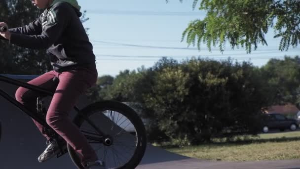 Bir çocuk Bmx Bisiklet hileler kaykay parkı güneşli bir günde biniyor. Çok yavaş hareket — Stok video
