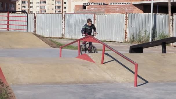 Een jongen is trucs Bmx fietsen in een skateboard park rijden op een zonnige dag. Super Slow Motion — Stockvideo