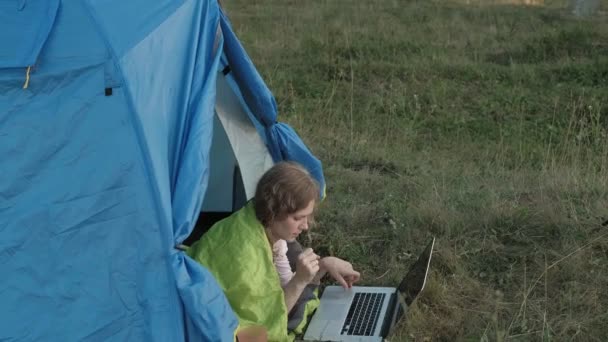 在一个旅游帐篷的笔记本电脑后面工作的年轻女子 — 图库视频影像