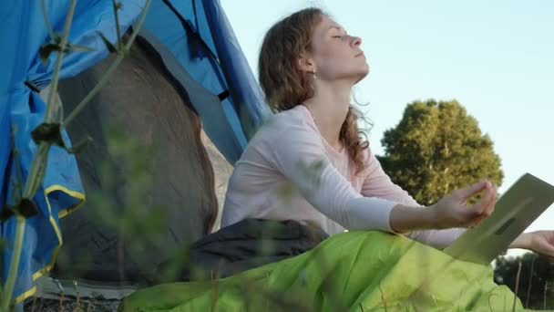 Jonge vrouw werken achter een laptop in een toeristische tent — Stockvideo