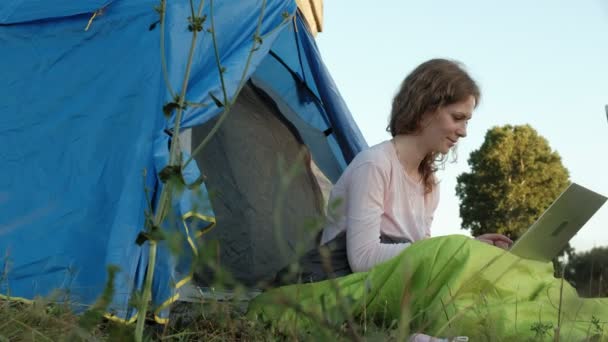 Bir dizüstü bilgisayar eski Köprüsü yakınlarında bir turist çadırda arkasında çalışan genç kadın — Stok video