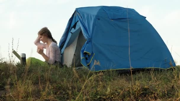Jonge vrouw werken achter een laptop in een toeristische tent — Stockvideo