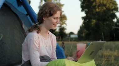 Bir dizüstü bilgisayar eski Köprüsü yakınlarında bir turist çadırda arkasında çalışan genç kadın