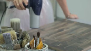 Atölye kadında ahşap kurullarında, antik bir efekt oluşturarak çalışıyor