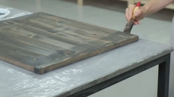 A mulher na oficina está trabalhando em tábuas de madeira, criando um efeito da antiguidade — Vídeo de Stock