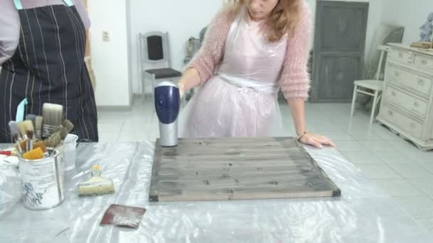 La mujer en el taller está trabajando en tablas de madera, creando un efecto de la antigüedad — Vídeo de stock