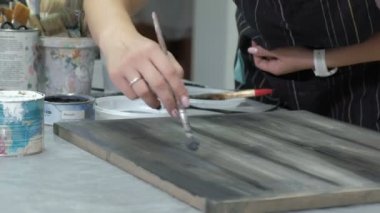 Atölye kadında ahşap kurullarında, antik bir efekt oluşturarak çalışıyor