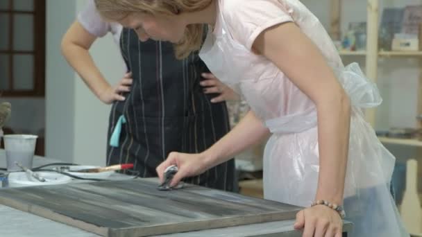 La mujer en el taller está trabajando en tablas de madera, creando un efecto de la antigüedad — Vídeo de stock