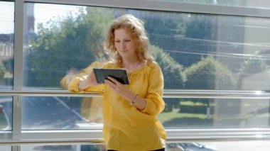 Pencerenin bir tablet ile genç güzel iş kadını