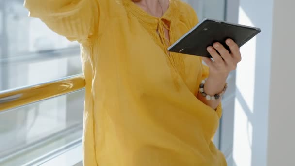 Young beautiful business woman, by the window with a tablet — Stock Video